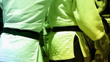 2 judoka fighting representing defensiveness, one of the 4 toxins of teamwork