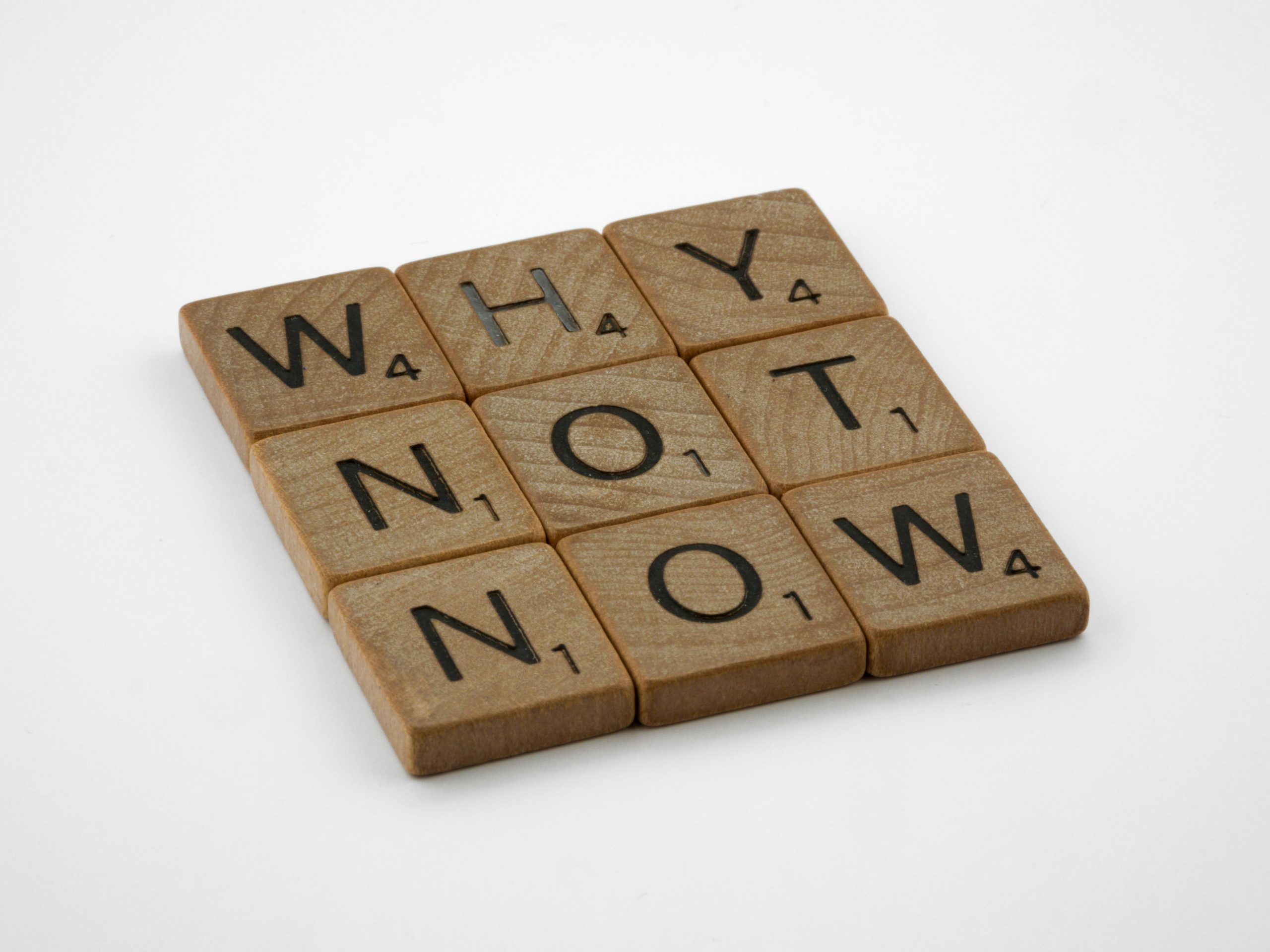 PIezas de scrabble que componen la frase "Why not now"